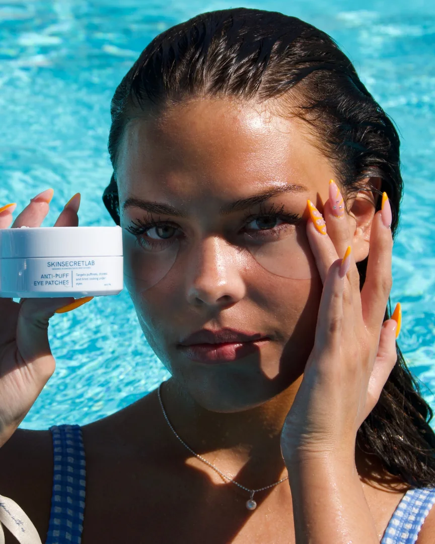 Modell i en pool håller Anti-Puff Eye Patches